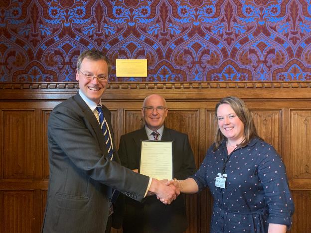 Cadent's Tony Moloney (centre) and Claire Noble receive the Youth Friendly certification from Michael Tomlinson MP