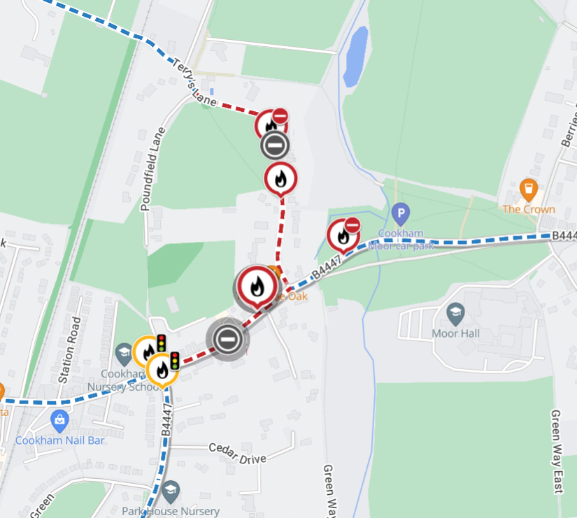 Map showing a road incident with fire icons and blocked routes in Cookham. Dashed red lines indicate closures and blue lines denote open roads.