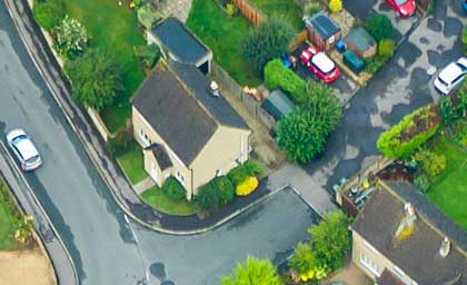 Aerial view of residential street with houses and cars