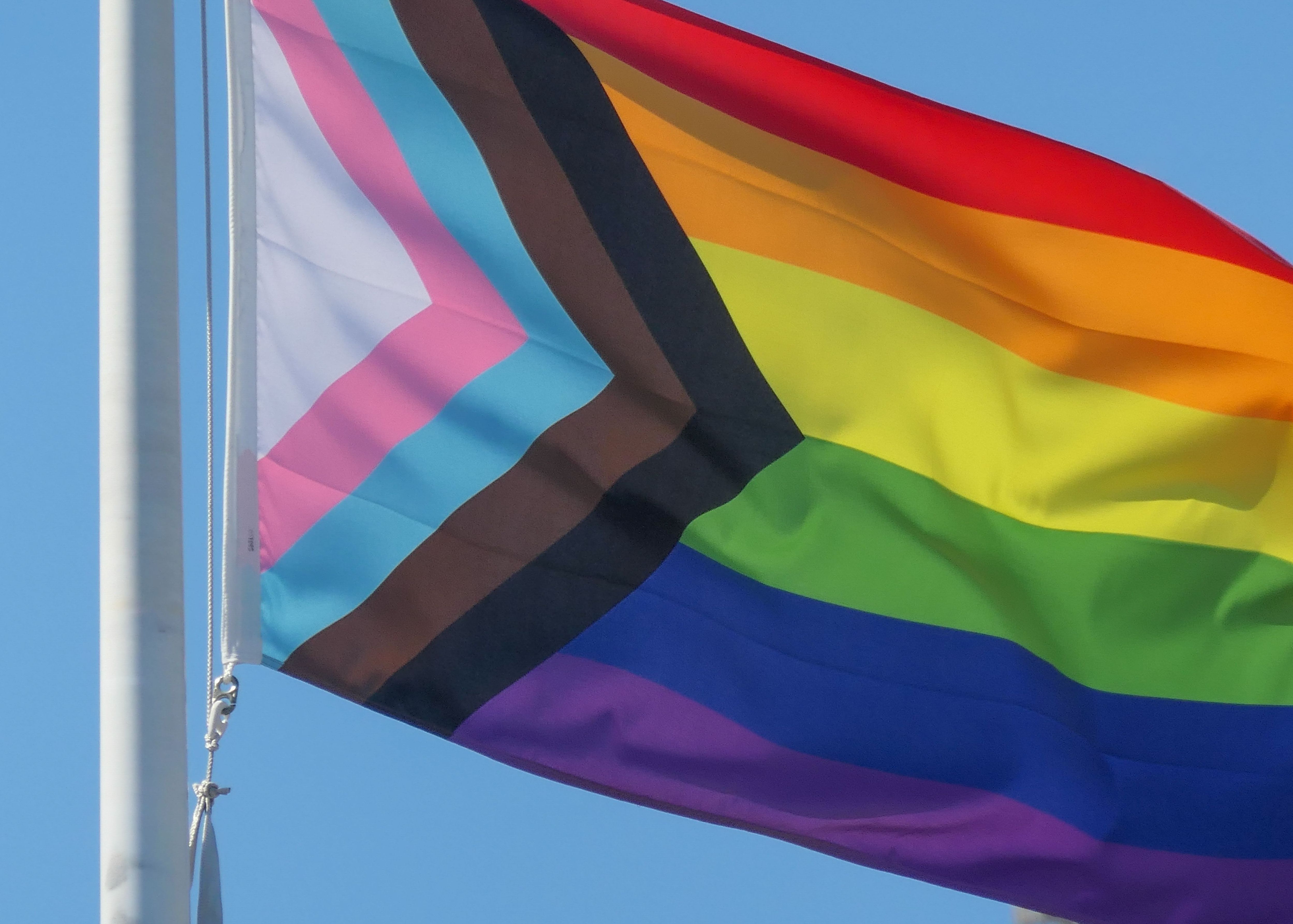 The Pride Progress Flag flies on a flagpole