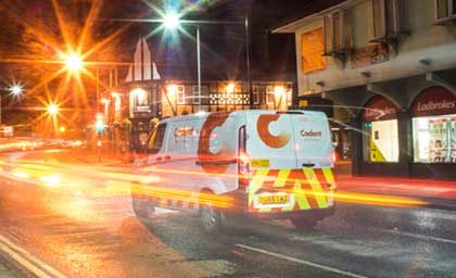 A white van with red and yellow stripes and a logo displaying 