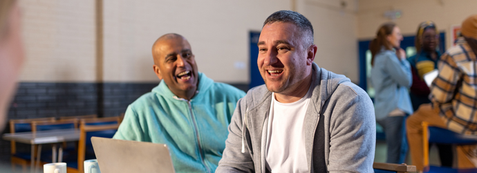 Team of people sitting on table with laptop