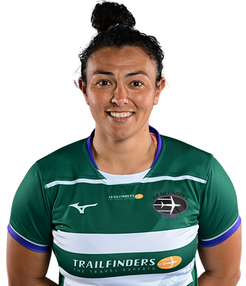 A woman in a green rugby jersey smiles against a black background. The jersey features logos and stripes, conveying a sporty and confident tone.