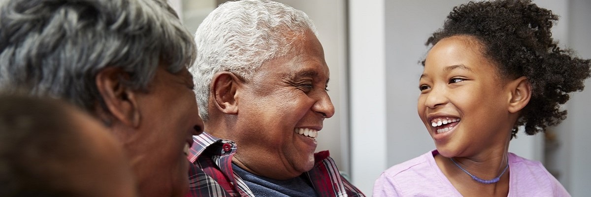 A close-up of two elder individuals and a child, in a joyful mood as they engage with each other in an indoor setting